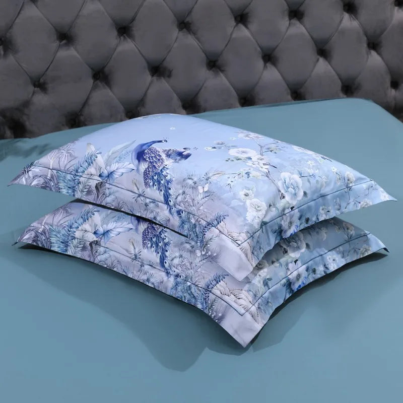Stacked sky blue botanical pillow shams featuring peacock and flowering branch artwork – L&B