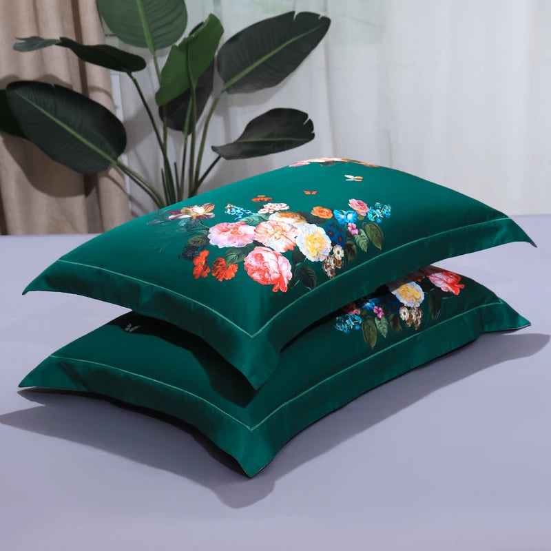 Stacked emerald green floral pillow shams with vivid botanical blooms and solid green reverse – L&B