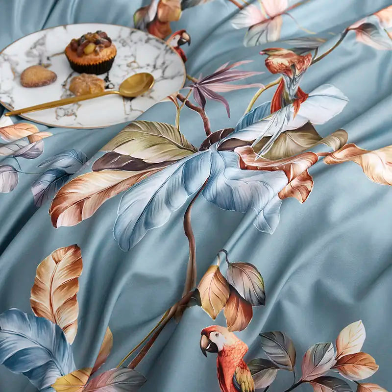 Close-up of colorful parrots and floral branches on the dusty blue Egyptian cotton duvet cover – L&B
