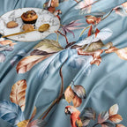 Close-up of colorful parrots and floral branches on the dusty blue Egyptian cotton duvet cover – L&B
