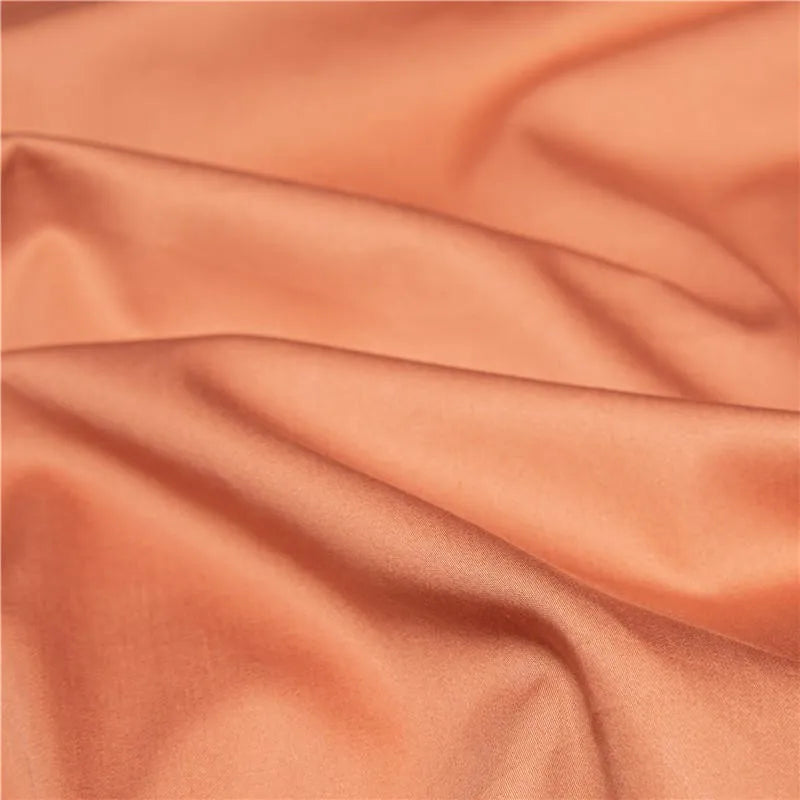 Close-up of smooth terracotta Egyptian cotton fabric with soft folds and a refined matte finish – NESLLA ORANGE BROWN – L&B