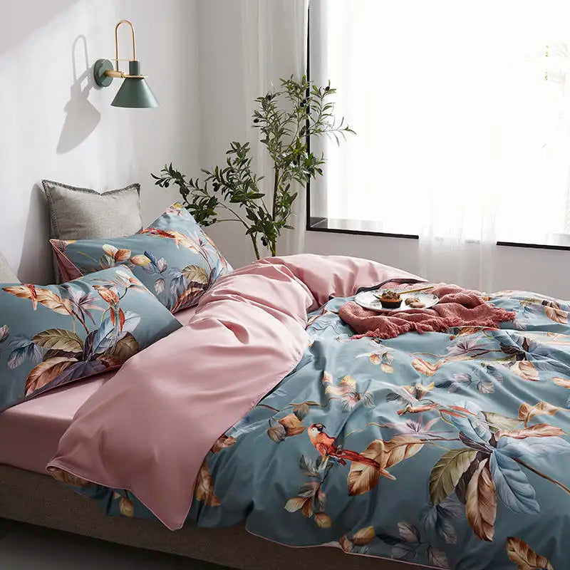 Blue tropical bird duvet cover styled with blush pink sheets and botanical pillow shams – L&B