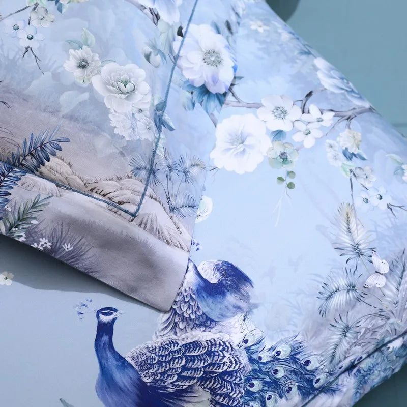 Close-up of peacocks, white blossoms and botanical branches on the LIGHT SKYRA duvet cover – L&B
