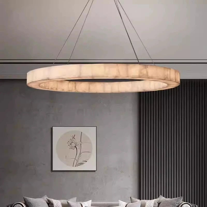 Modern ring alabaster chandelier with a gold canopy in a contemporary gray living room