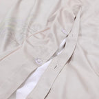 Button closure detail on the matching beige reverse of the FLIFLOWERS duvet cover – L&B