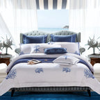 White and blue coastal duvet cover set with embroidered coral and starfish motifs in an ocean-view bedroom – L&B