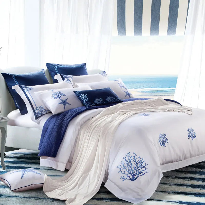 White coastal bedding set with blue sea life embroidery and layered nautical accent pillows – L&B