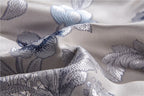 Close-up of sculptural floral embroidery on champagne silk and Egyptian cotton bedding, STOPIAK – L&B