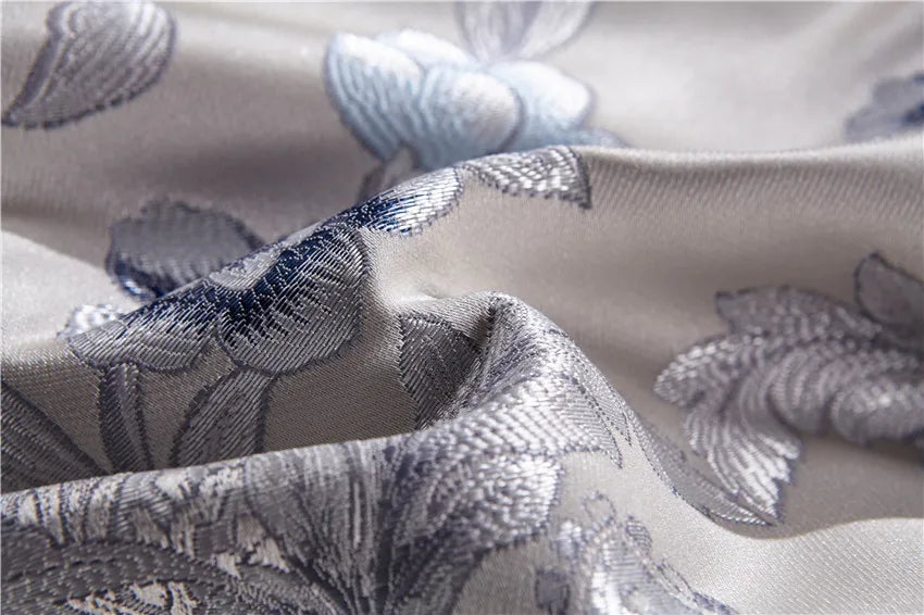 Close-up of sculptural floral embroidery on champagne silk and Egyptian cotton bedding, STOPIAK – L&B