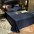 Coordinating solid black bedspread styled with floral embroidered pillow shams, PERIK – L&B