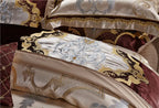 Layered champagne gold baroque pillows with rich wine red accents, SPECTO – L&B