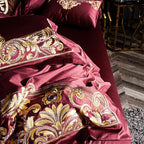 Close-up of gilded baroque scroll embroidery on a burgundy duvet cover, ZUTAPERA – L&B