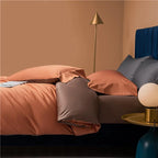 Rust orange and brown bedding displayed in a modern bedroom with a navy upholstered headboard – NESLLA ORANGE BROWN – L&B