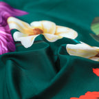 Close-up of smooth emerald green Egyptian cotton with colorful botanical flower detailing – L&B
