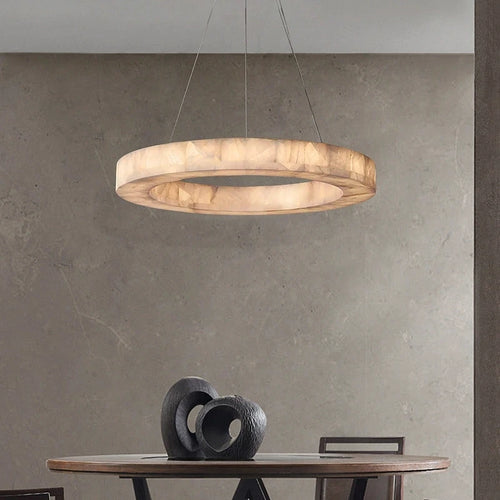 Alabaster ring chandelier above a minimalist dining table in a warm modern interior