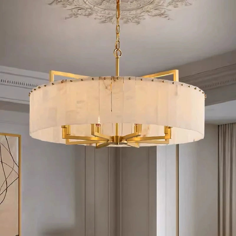 Modern alabaster drum chandelier with a gold frame in a transitional living room