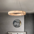 Alabaster halo chandelier with a gold canopy above a console table in a contemporary interior