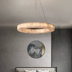 Alabaster halo chandelier with a gold canopy above a console table in a contemporary interior