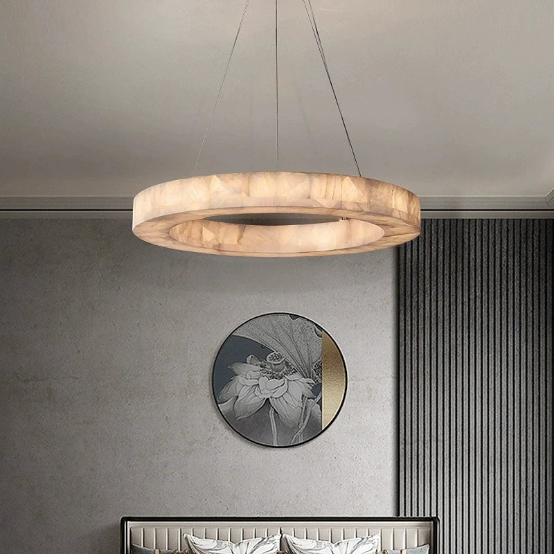 Alabaster halo chandelier with a gold canopy above a console table in a contemporary interior