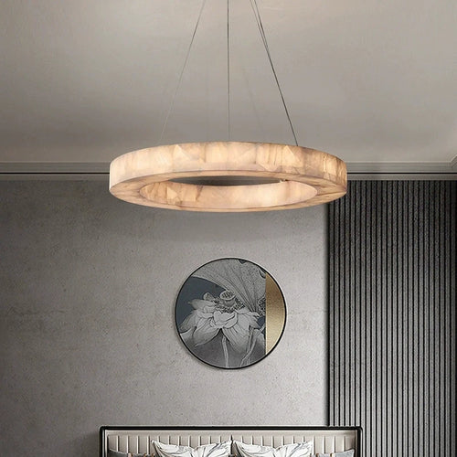 Alabaster halo chandelier with a gold canopy above a console table in a contemporary interior