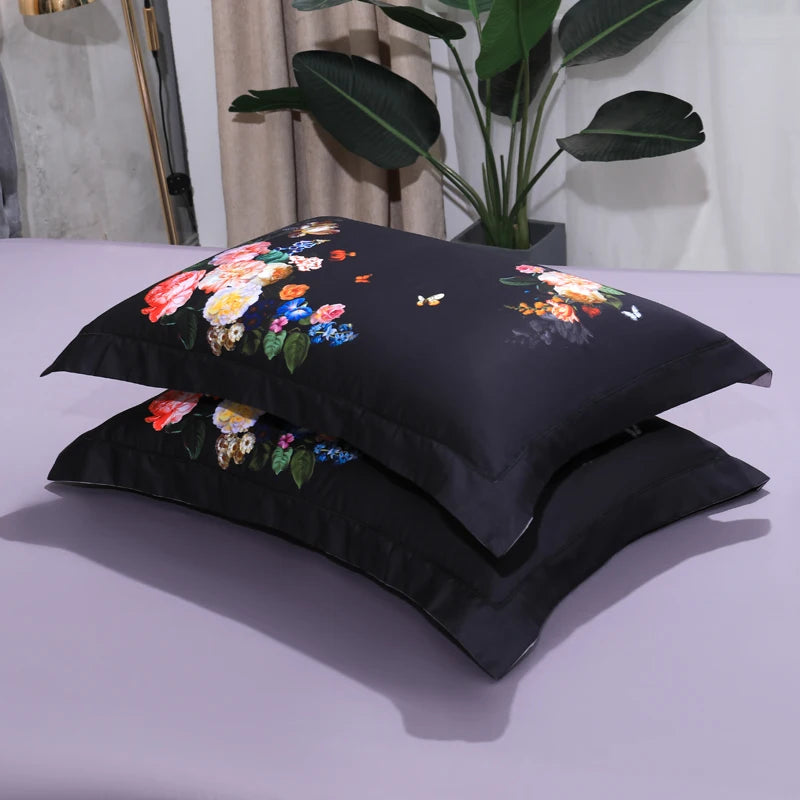 Stacked black floral pillow shams with colorful botanical blooms on gray bedding – L&B