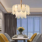 Modern 2-tier alabaster chandelier above a dining table in a warm contemporary dining room - L&B