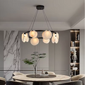 Alabaster disc ring chandelier above a round dining table in an organic modern dining room - L&B