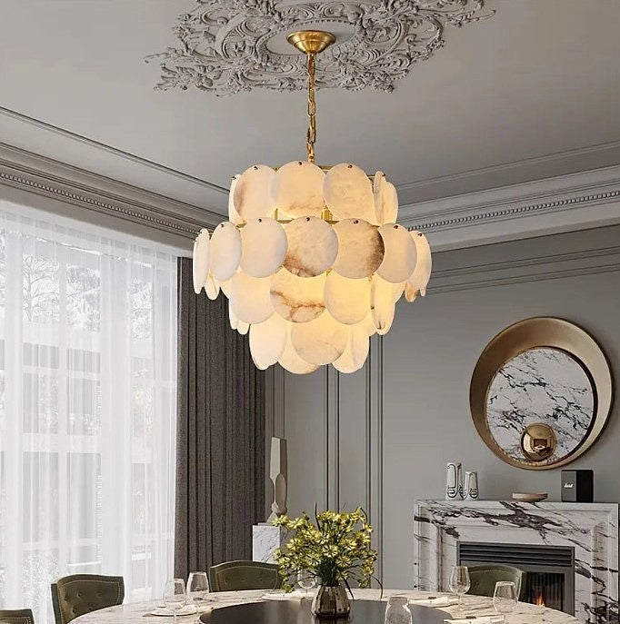 Round tiered alabaster chandelier above a dining table in a transitional dining room - L&B