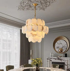 Round tiered alabaster chandelier above a dining table in a transitional dining room - L&B