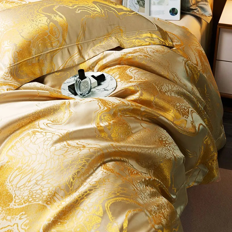 Close-up of a champagne gold jacquard duvet cover with fluid ornamental lines and a soft lustrous drape – L&B