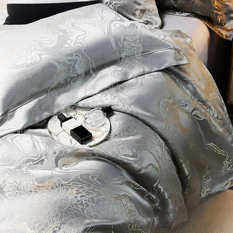 Close-up of silver gray jacquard bedding with softly gathered folds, platinum threadwork, and a luminous woven finish – L&B