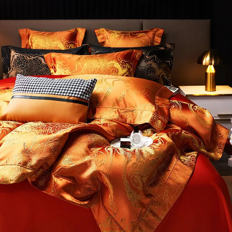 Close-up of burnt orange bedding with an ornate jacquard duvet cover, matching shams, and decorative accent pillow – L&B