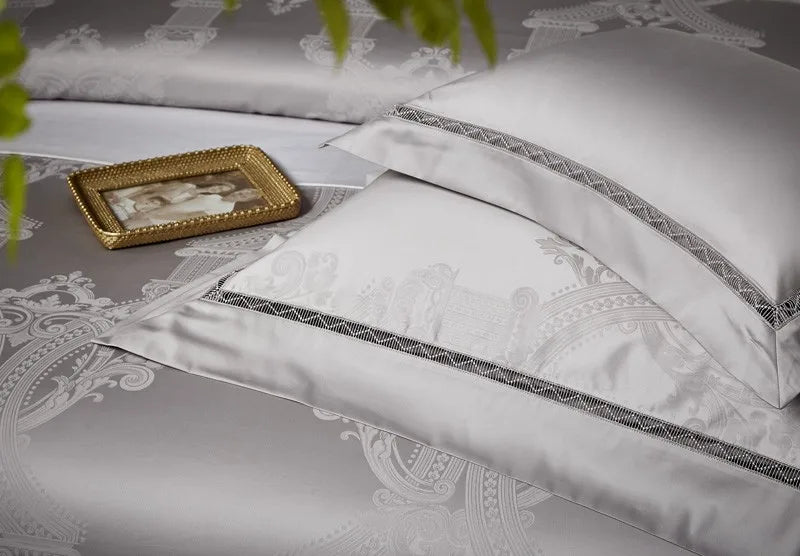 Layered silver gray pillow shams and damask duvet cover with tonal piping and a lustrous satin finish – L&B