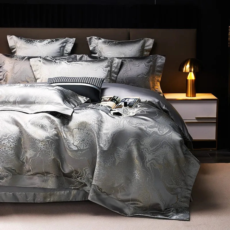 Gray jacquard bedding set with a shimmering silver duvet cover and layered pillows on an elegantly styled bed – L&B