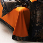 Black gold duvet cover draped over a burnt orange sheet, highlighting the bold reversible color contrast – L&B