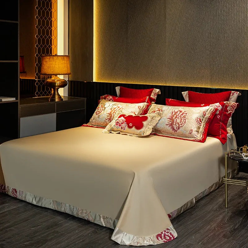 Ivory Egyptian cotton flat sheet styled with red floral embroidered pillows and a smooth satin finish – L&B