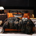 Black and gold jacquard duvet cover set with coordinating shams and orange accent pillows in a modern bedroom – L&B