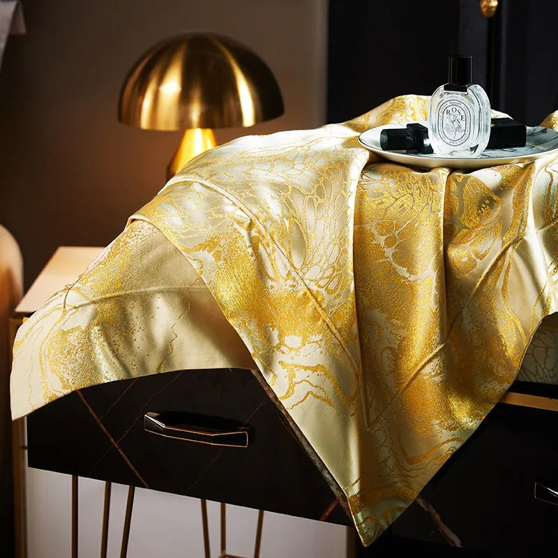 Side view of a gold jacquard duvet cover draped over a contemporary bed with a rich champagne sheen – L&B