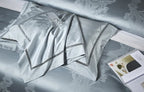Folded sky blue Egyptian cotton bedding with layered damask shams, satin sheen, and tailored couture trim – L&B