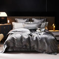 Charcoal gray jacquard duvet cover set with matching shams and layered pillows in a modern luxury bedroom – L&B