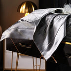 Side view of a dark gray jacquard duvet cover with a flowing drape and reflective metallic finish – L&B