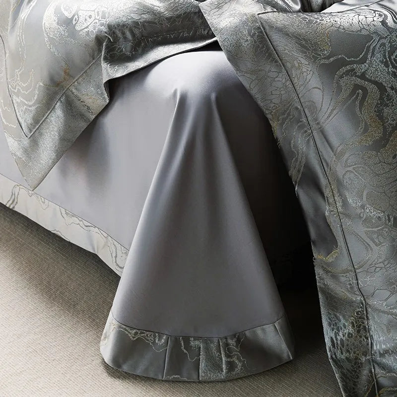 Silver jacquard duvet cover draped over a smooth gray Egyptian cotton sheet with a tailored ruffle border – L&B