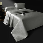 Pewter gray quilted bedspread layered over an abstract geometric jacquard duvet, LUSTRA PEWTER – L&B