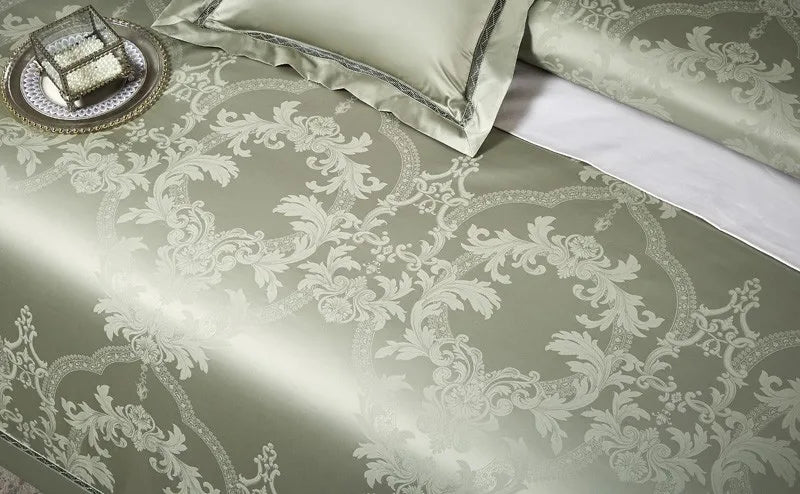 Close-up of sage green damask jacquard bedding showing the architectural baroque pattern and woven texture – L&B