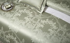 Close-up of sage green damask jacquard bedding showing the architectural baroque pattern and woven texture – L&B