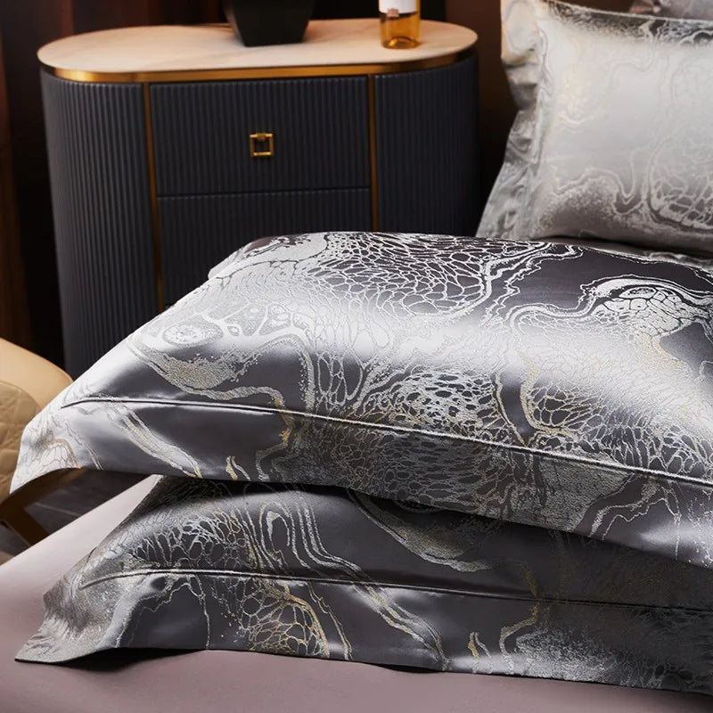 Dark gray jacquard pillow shams stacked to display their metallic woven pattern and sophisticated charcoal sheen – L&B