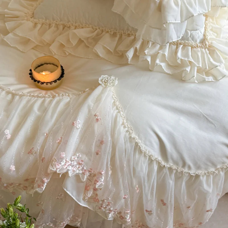 Ivory lace bedding with delicate pink floral embroidery, scalloped trim, and gathered cotton ruffles – L&B