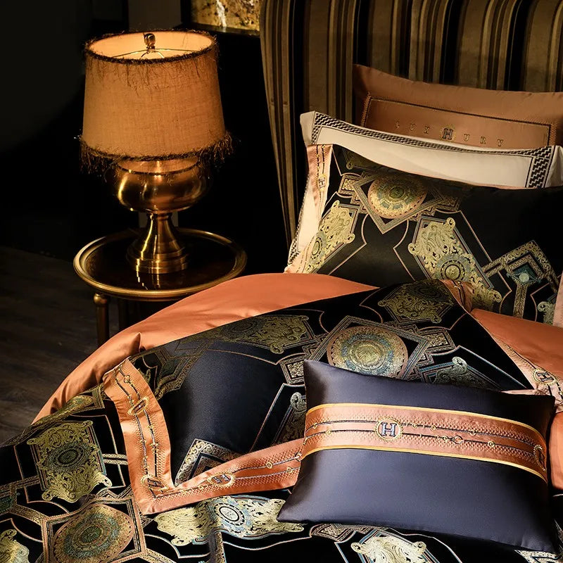 Luxury black bedding styled with gold medallion motifs and copper decorative pillows beside a table lamp – ROYAL H. BLACK – L&B