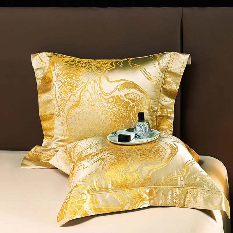Gold satin jacquard pillow sham and matching duvet cover displayed with an elegant fluid marble pattern – L&B