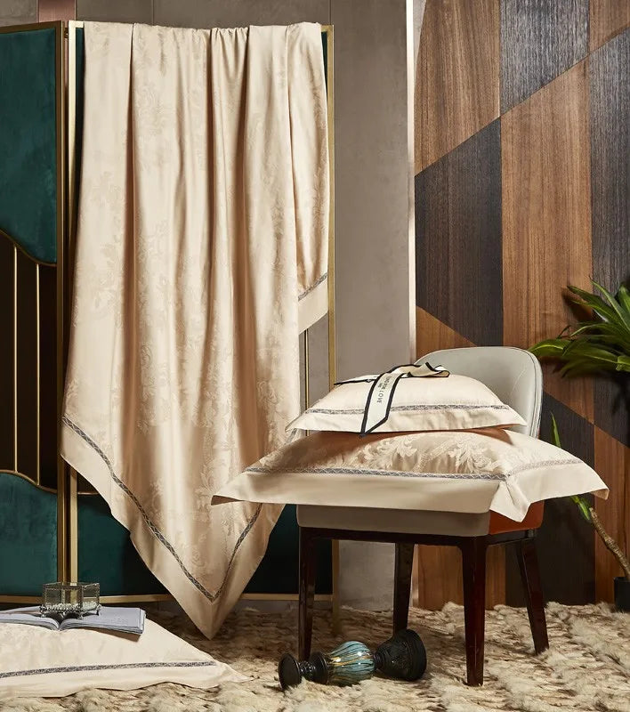 Gold damask bedding draped over an accent chair to display its flowing satin finish and elegant jacquard pattern - L&B